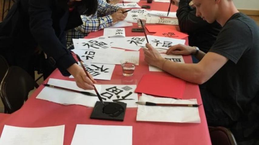 People practicing Asian calligraphy