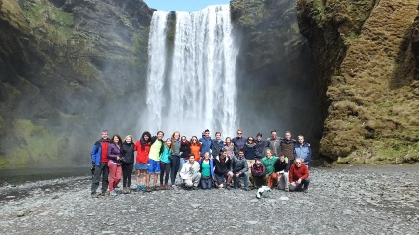 Group posing in front of a large waterfall