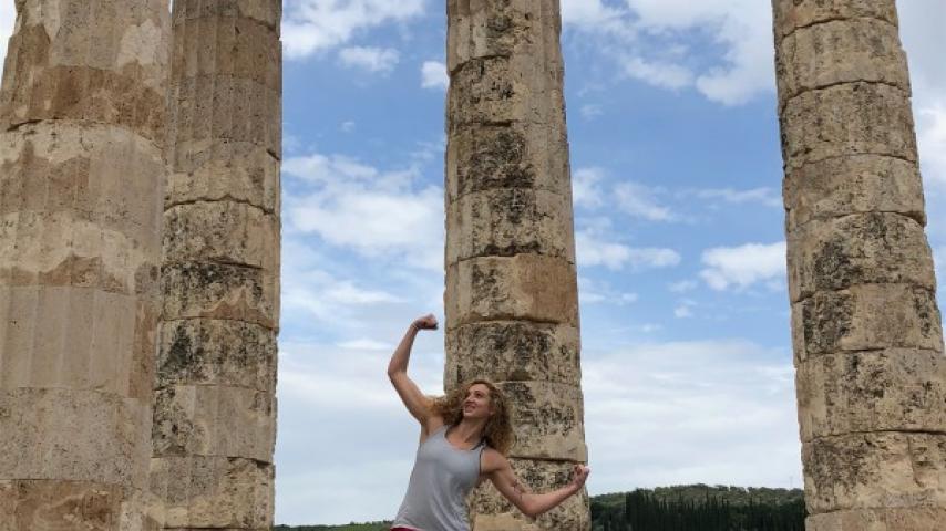 Student posing with Greek columns