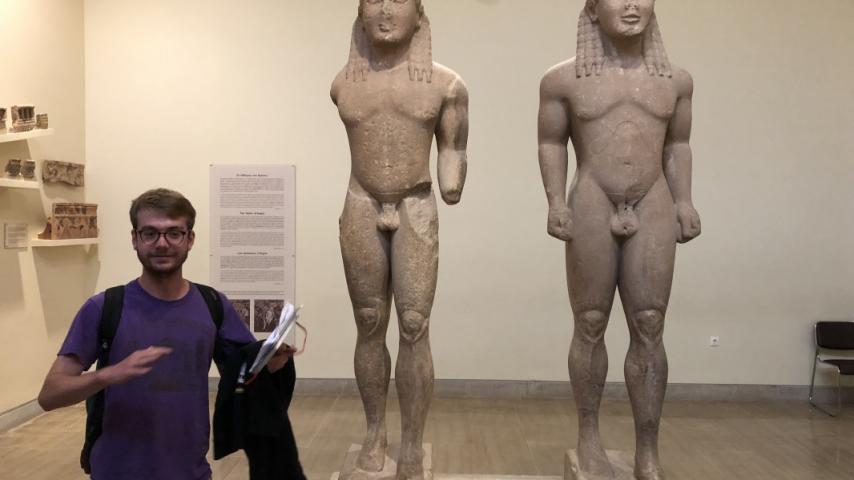 Student with ancient statues in a museum