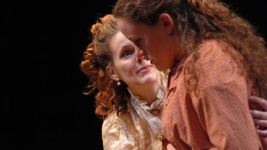 Two women in costume acting on stage