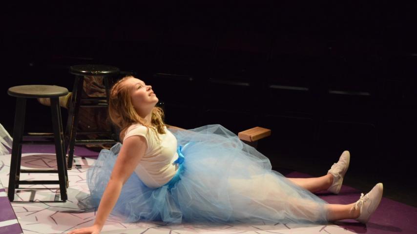 Actress in a tutu sitting on stage