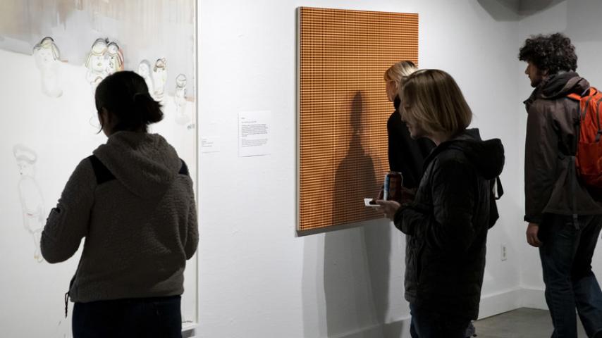 People looking at artworks on a gallery wall
