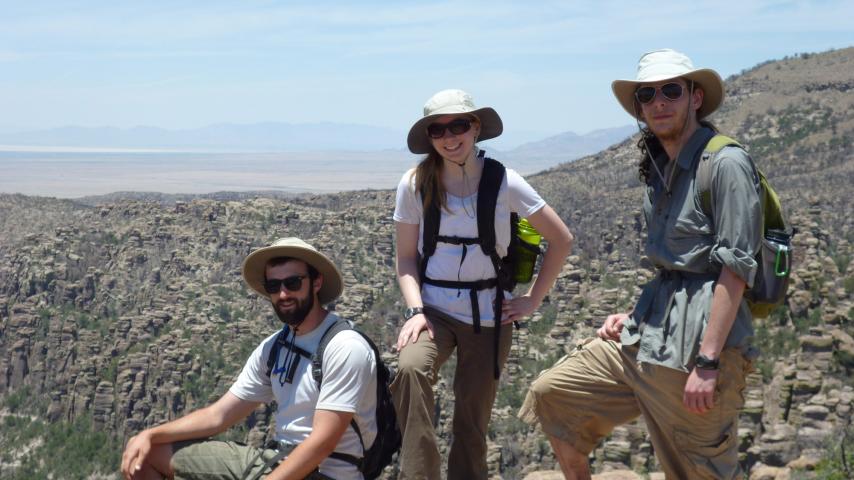 Students perch on a rock outcrop while conducting fieldwork