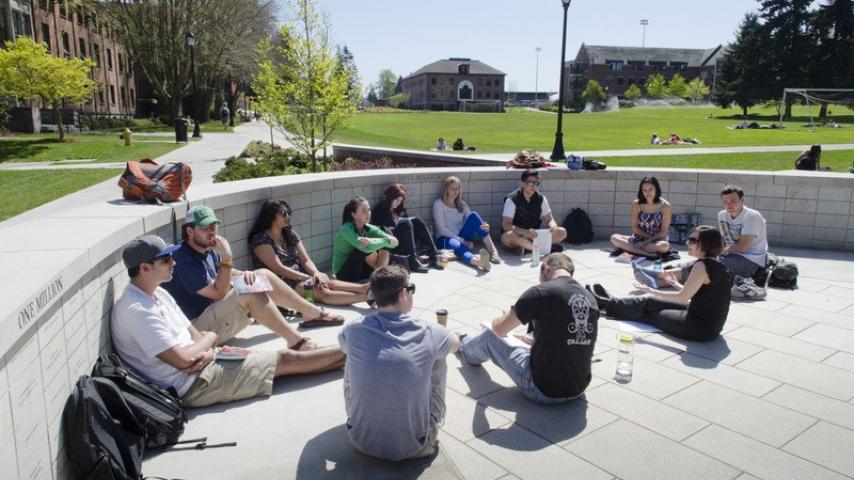 A student group sitting inside Benefactor Plaza