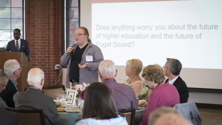 Person with a microphone presenting at a function