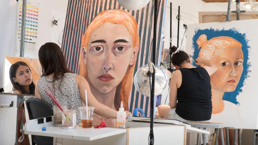 Students painting portraits on canvas