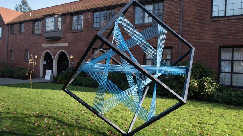 A 3D cube sculpture outside a university building
