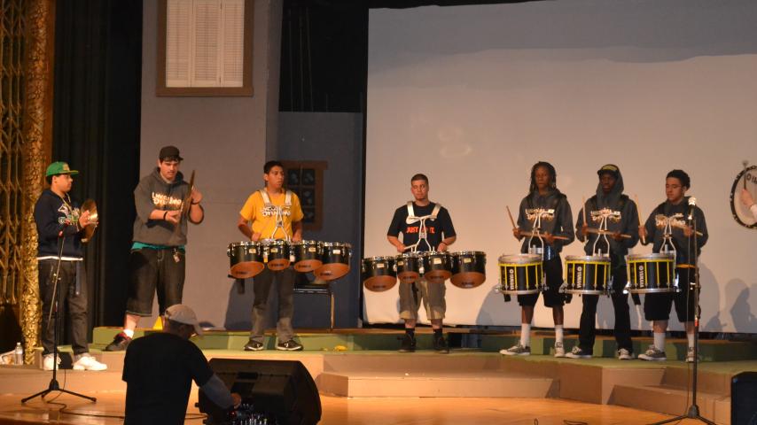 Students with drums on a stage