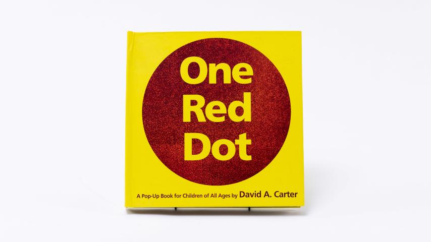A bold red circle on yellow on the cover of One Red Dot.