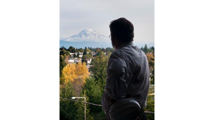 President Ron Thomas admires the view of Mount Rainier from campus.