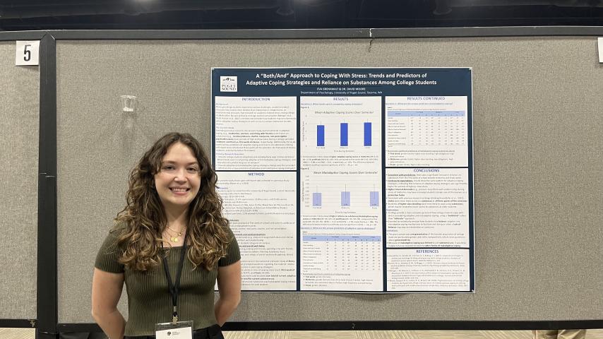 Psychology student Eva Grenawalt standing next to her research poster at the WPA conference