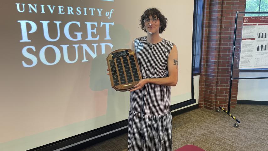 Hayden Smith holding up the Abigail Mattson award plaque after receiving the award