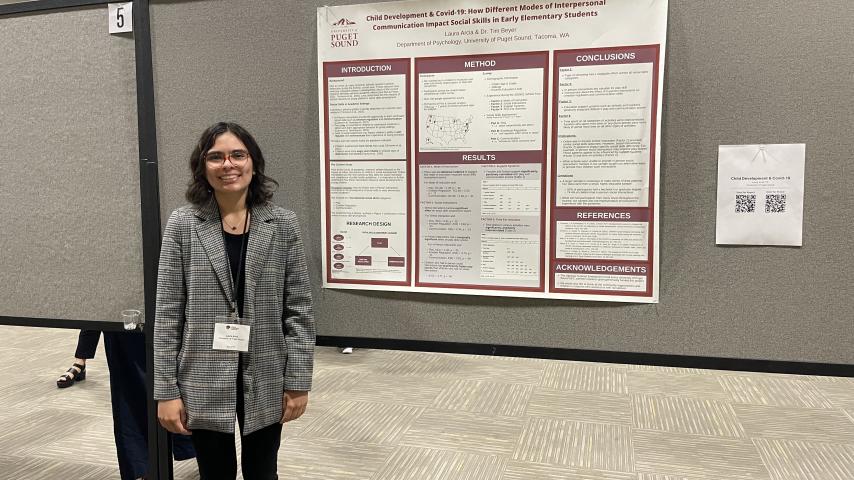 Psychology student Laura Arcia standing next to her research poster at the WPA conference