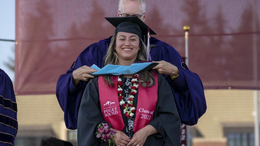 A graduate student receives her hood.