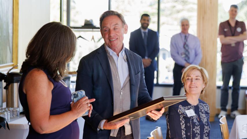 Chair Robert Pohlad P'07 receives a special recognition for his years of dedicated leadership from Chair elect Beth Picardo '83, JD'86 as trustee Laura Inveen '76 looks on.