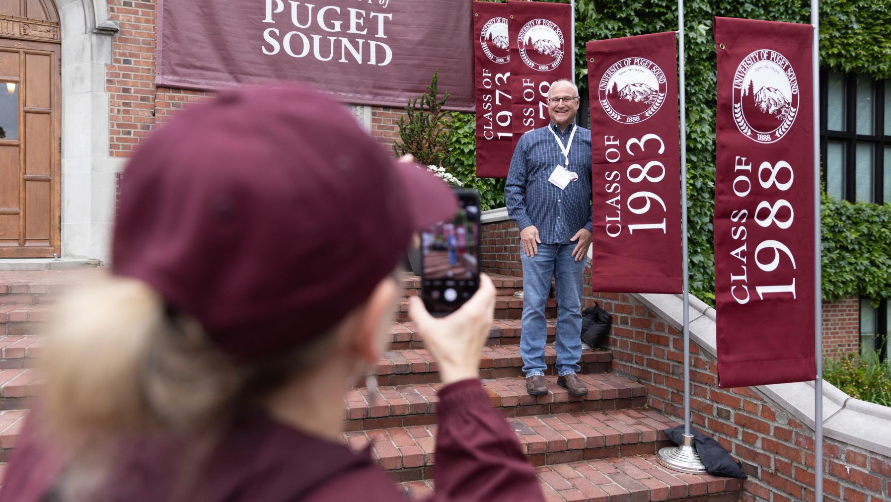 An alumnus from the Class of 1983 stands on the steps of Jones Hall to have his picture taken.