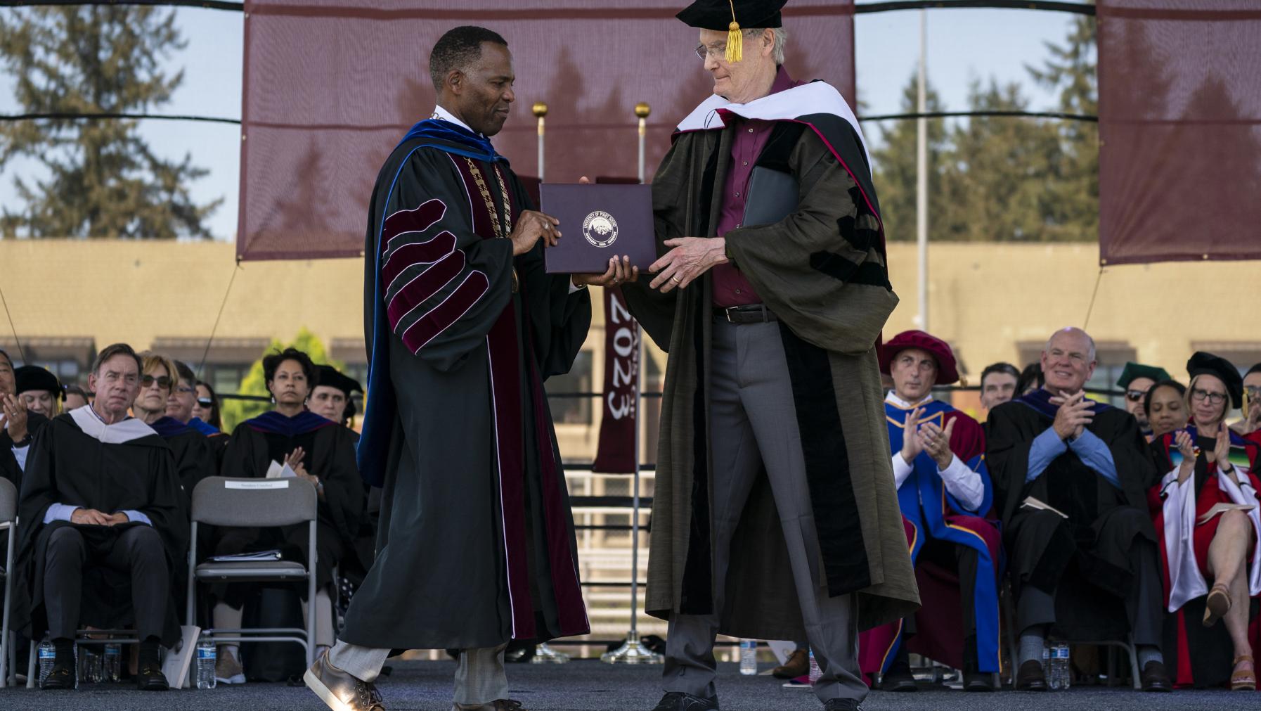 President Crawford presents Bill Baarsma '64, P'93 with an honorary degree.