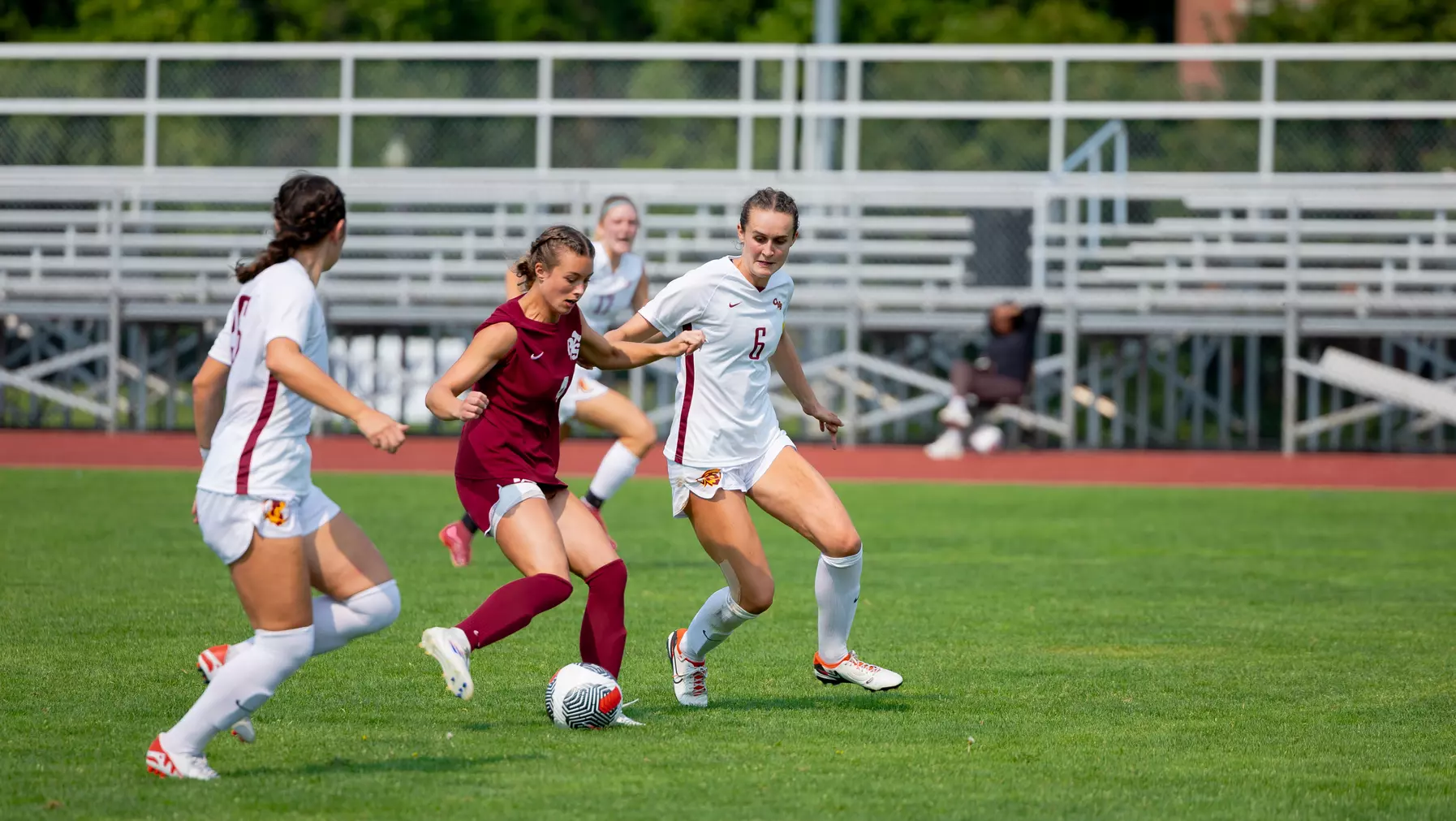 UPS Women's soccer player evading two Claremont soccer players
