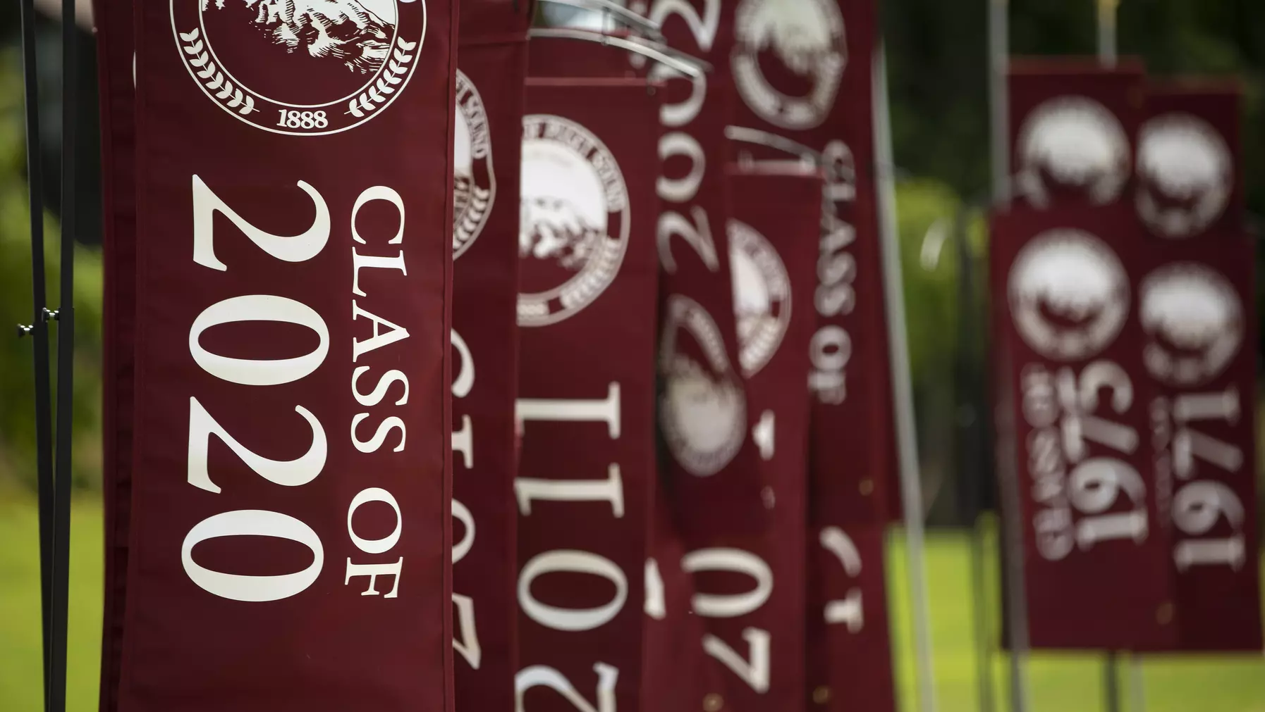 A long row of flags that all have the UPS logo and read "class of" followed by a year 