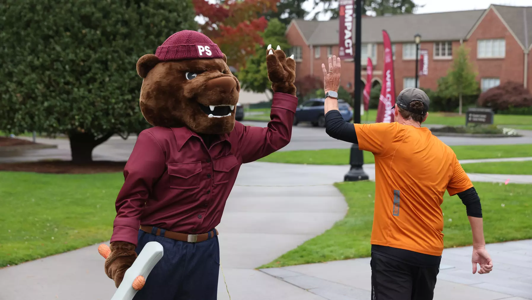 Grizz congratulates runners at the finish line at the 15th Annual Logger 5K on Oct. 12, 2025.