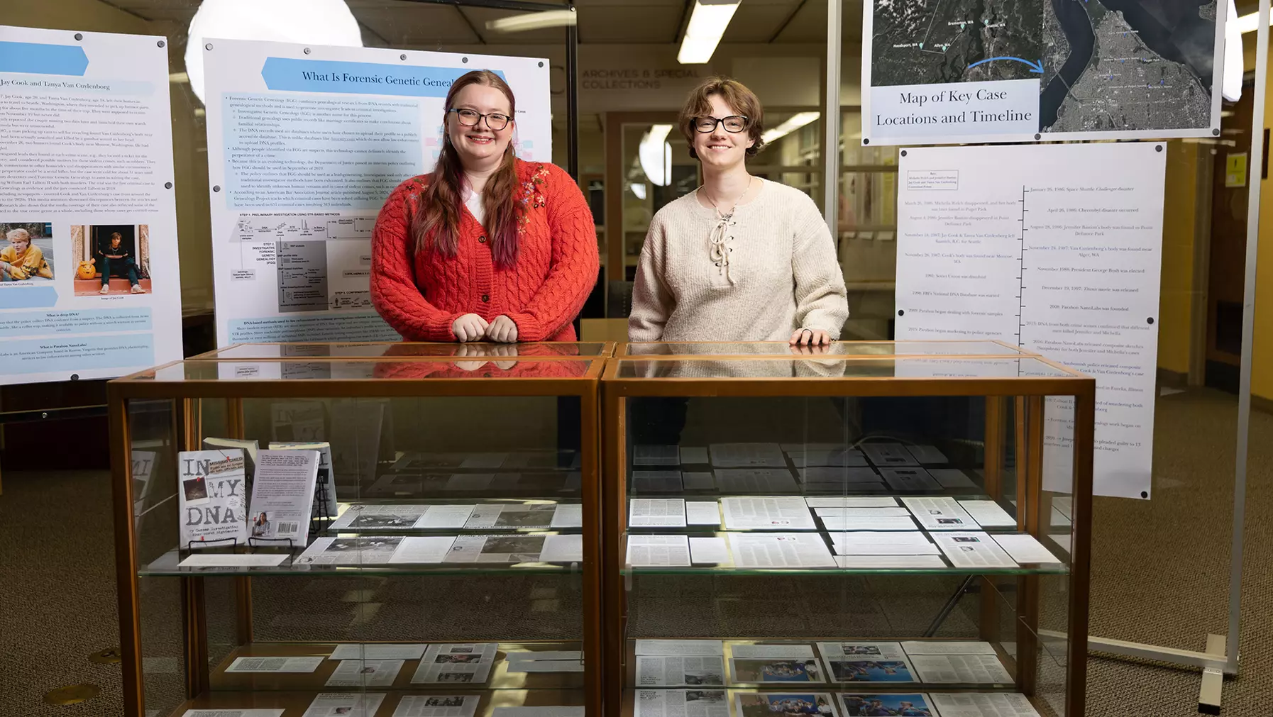 Anna Brown and Cas Unruh pose for photos near their displays at the Archives & Special Collections in Collins Library