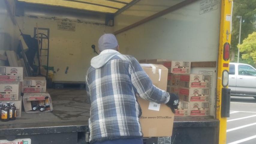 A person moving some boxes into a truck.