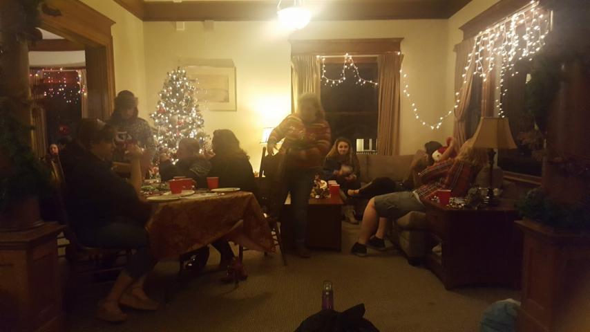 People sitting at a table in front of a Christmas tree.