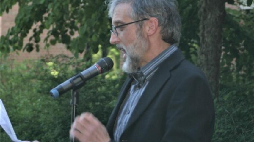 A person speaking at a microphone.