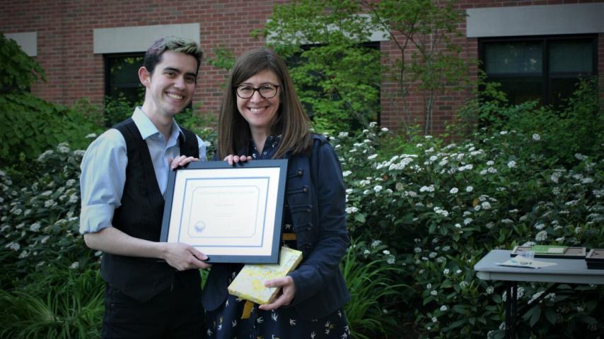 Two people smiling with an award.