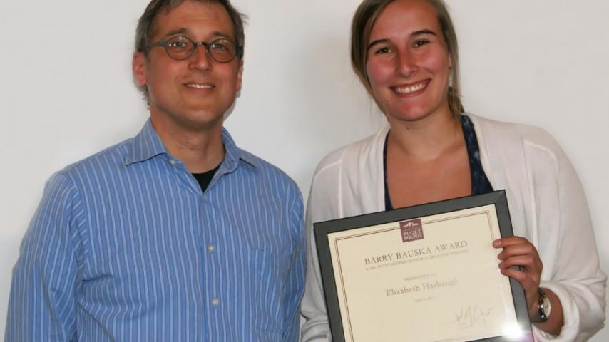 Two people smiling with an award.