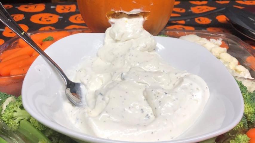 A carved pumpking and a plate of ranch.