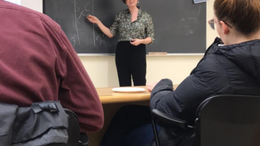 A person pointing at a chalkboard.