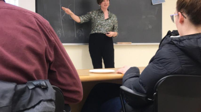 A person pointing at a chalkboard.