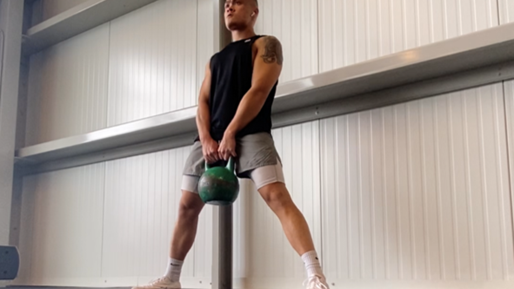 A person holding a kettlebell.