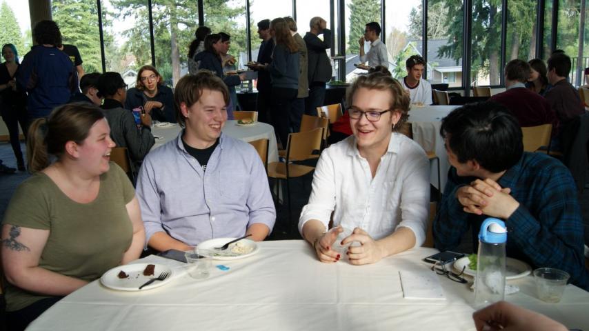 Four people laughing at a table.