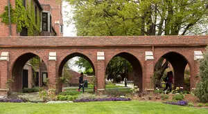 Student walks through the arches
