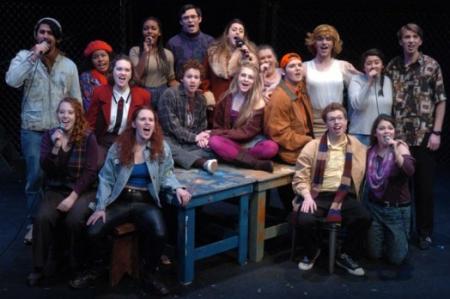 Cast of rent singing on stage in a group