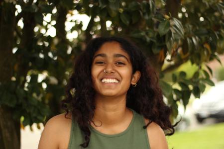 Photo of Sowmya standing in front of a tree and smiling