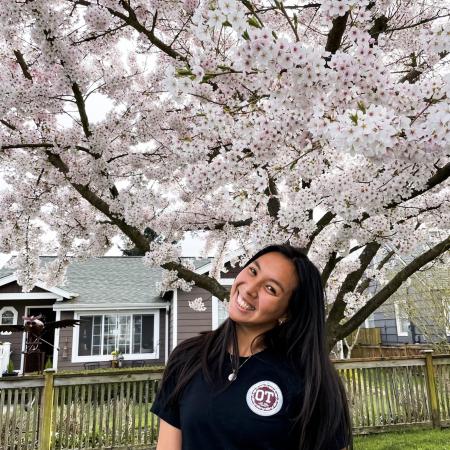 Kiana Serraor pictured in front of a blooming apple blossoms.