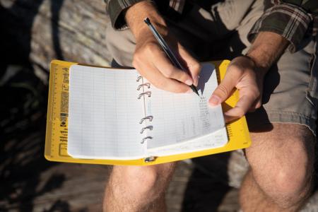 A student makes notes in a logbook