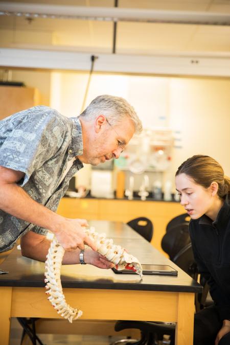Roger Allen shows a model spine to a physical therapy student.