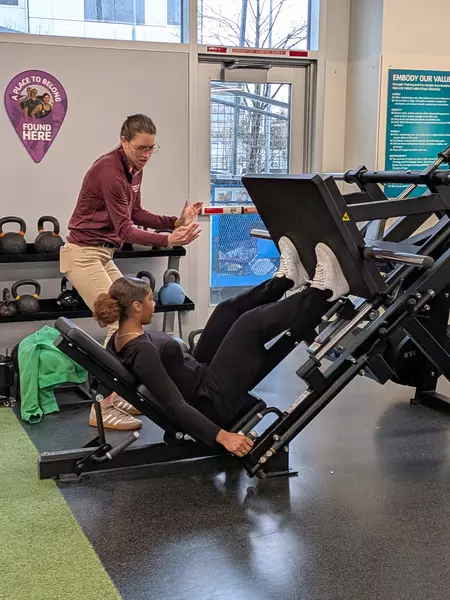 A Puget Sound PT student instructs a high school student on proper form in the weight room. 