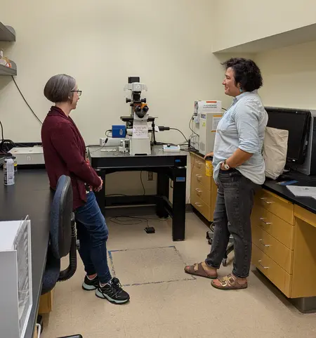 Science Core Facility Technician Amy Replogle and Rep. Emily Randall discuss the aging microscope.