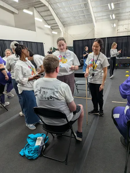 Three volunteers talk to an athlete sitting in front of them. 