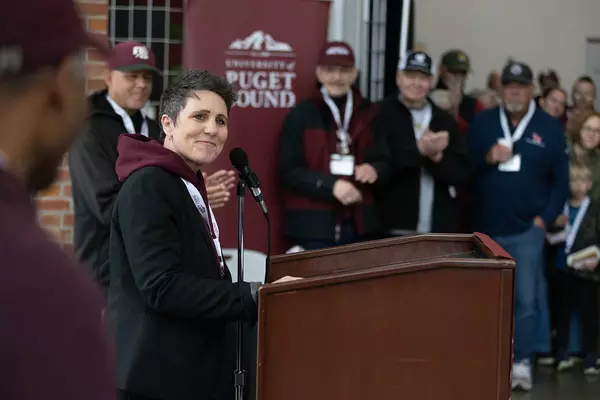 Athletic Director Chelsea Herman speaks at the podium.