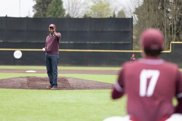 President Isiaah Crawford points at the catcher before throwing the first pitch. 