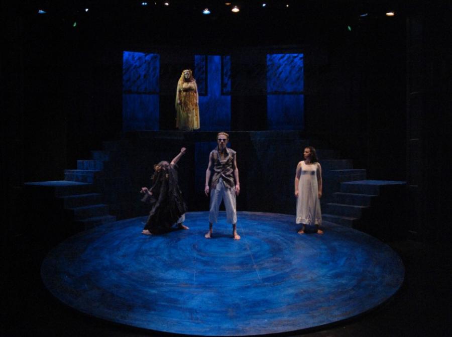 Four actors on a stage in blue lighting