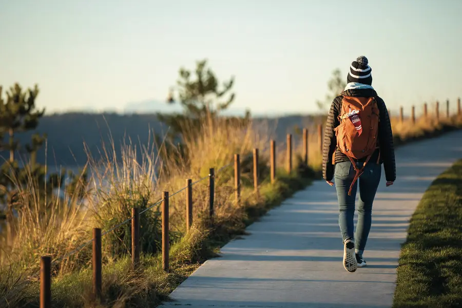 A student walks through Dune Peninsula Park along Tacoma's waterfront.